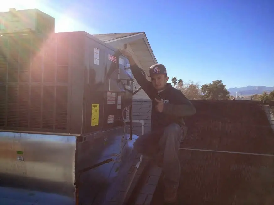 HVAC technician performing AC Tune-Up on a rooftop unit in Horn Lake